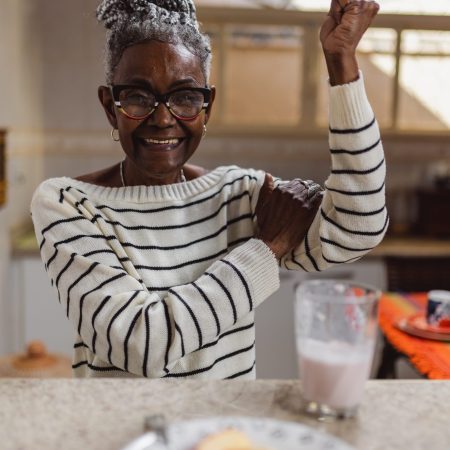 Cheerful elderly woman states that she is still strong.